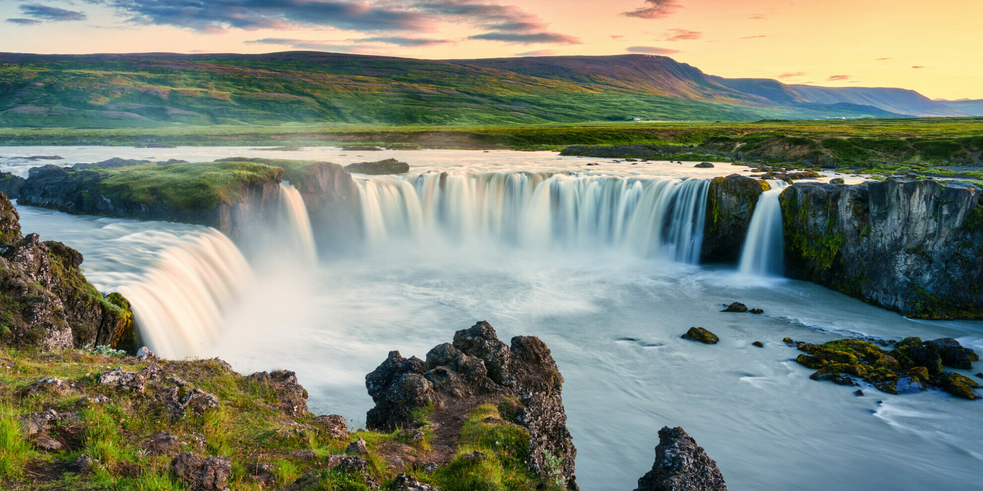 Majestic landscape of Godafoss waterfall or waterfall of the gods flowing and colorful sunset sky on Skjalfandafljot river in summer at Northern Iceland