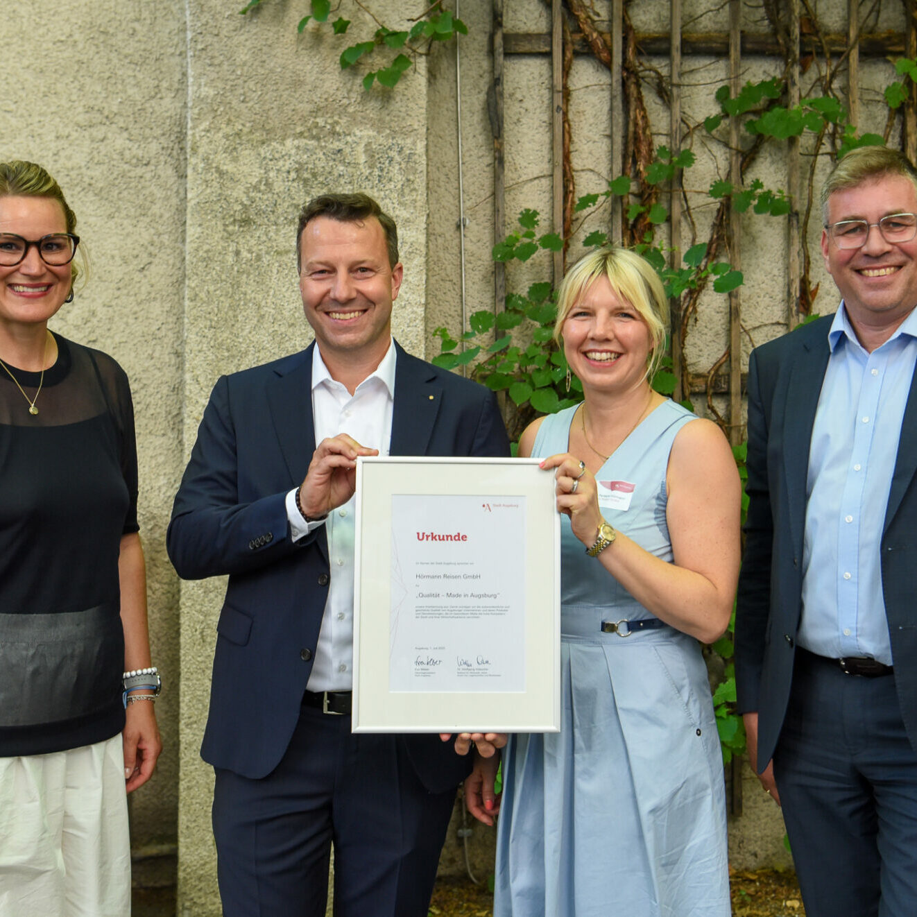 Brunnenhof im Zeughaus 
Stadt ehrt Unternehmen für „Qualität –
Made in Augsburg“.
Hörmann Reisen GmbH.
Mit OB Eva Weber und Wirtschaftsreferent Dr. Wolfgang Hübschle.
Auszeichnung für Leistungen, die dem Wirtschaftsstandort Profil geben.