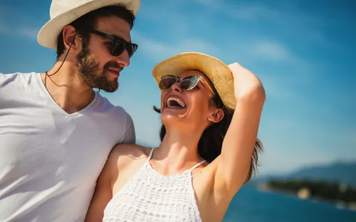 Junge schöne touristische Paare, die Sommerferien auf der Küste genießen