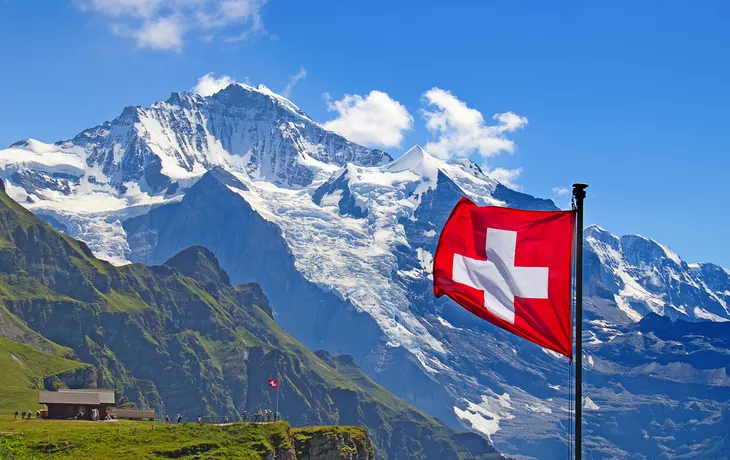 Schweizer Flagge vor dem Berg Jungfrau in der Schweiz