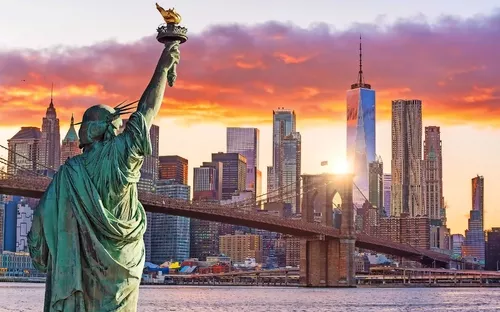 Freiheitsstatue und Manhattan-Skyline bei Sonnenuntergang