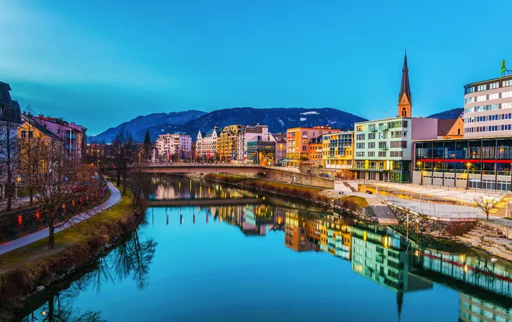 Blick auf ein Flussufer der Drau bei Sonnenuntergang in Villach,Österreich,
