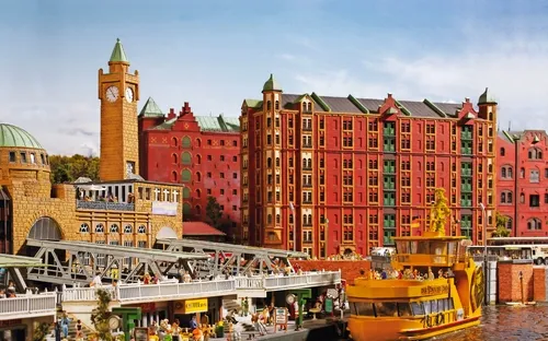 Bunte Stadt mit Kirchen und Kuppel auf Hügel unter blauem Himmel.