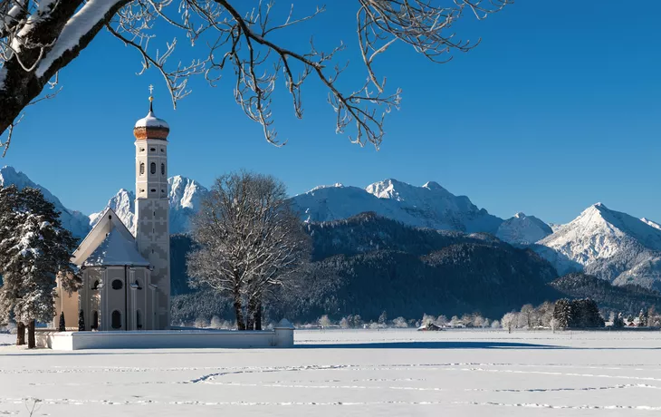 Panorama von Winterlandschaft mit Kirche St. Coloman bei Füssen im Allgäu