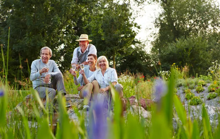 Gruppe Senioren beim Sekt trinken im Garten