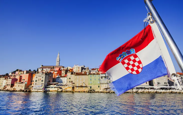 Flagge Kroatiens mit der Stadt Rovinj im Hintergrund