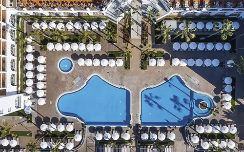 Kirche in italienischer Stadtlandschaft bei Sonnenuntergang, umgeben von Hügeln und Gebäuden.