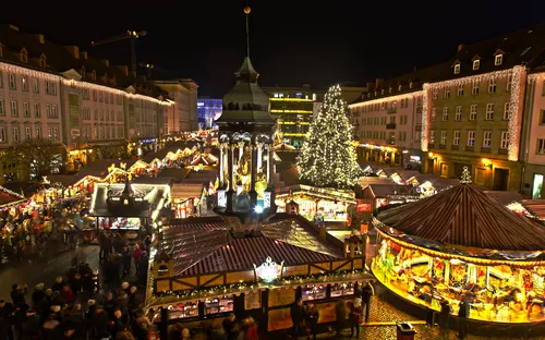 Weihnachtsmarkt bei Nacht mit Lichtern und geschmücktem Baum