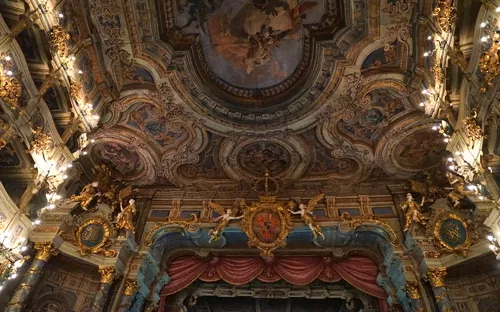 Deckenfresko und opulente Verzierungen eines prunkvollen barocken Theatersaals.