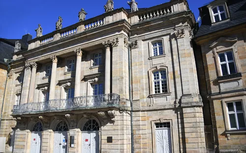 Historische Fassade eines Gebäudes mit Säulen und Statuen.