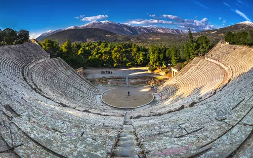 Griechisches Amphitheater mit Blick auf umliegende Wälder und Berge.