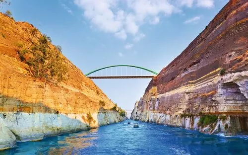 Brücke über einer Meerenge mit hohen Felswänden und blauem Wasser darunter.
