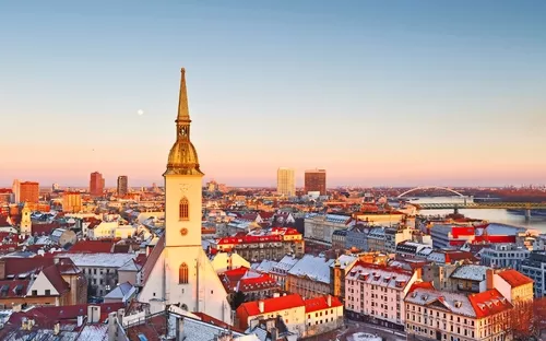 Winterlicher Stadtblick auf Kirche und historische Gebäude bei Sonnenuntergang.