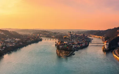 Flusspanorama bei Sonnenuntergang mit Stadt und Brücken im Hintergrund