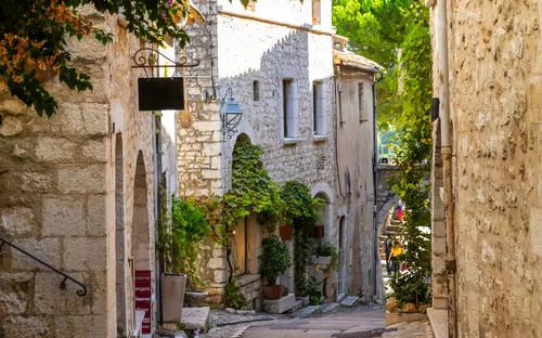 Malerische alte Gasse mit steinernen Häusern und Pflanzen.