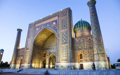 Märchenhafte Moschee mit bunten Mosaiken und blauer Kuppel bei Dämmerung.