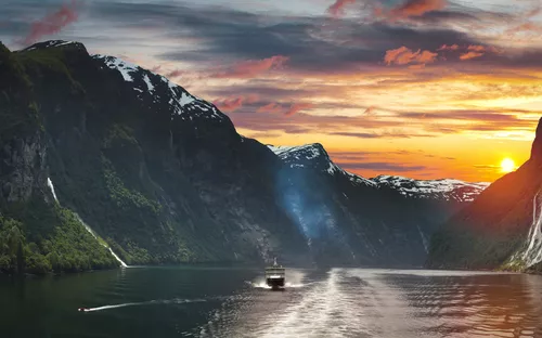 Boot auf Fjord bei Sonnenuntergang, umgeben von Bergen und Wasserfällen.