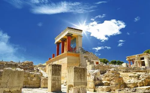 Ruinen des Palasts von Knossos auf Kreta bei sonnigem Wetter mit blauem Himmel und einigen Wolken.