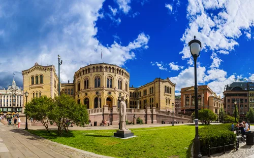 Historisches Gebäude mit Garten und blauem Himmel.