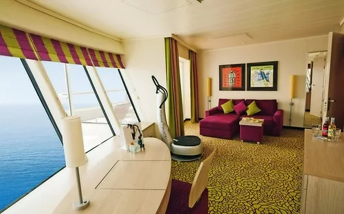 Ein luxuriöses Kreuzfahrtschiffzimmer mit Meerblick und Sofa.