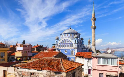 Blaue Moschee mit Minarett und umliegenden Gebäuden unter klarem Himmel