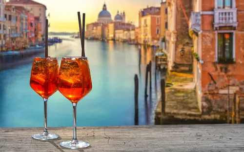 Zwei Aperol Spritz vor venezianischem Kanal bei Sonnenuntergang