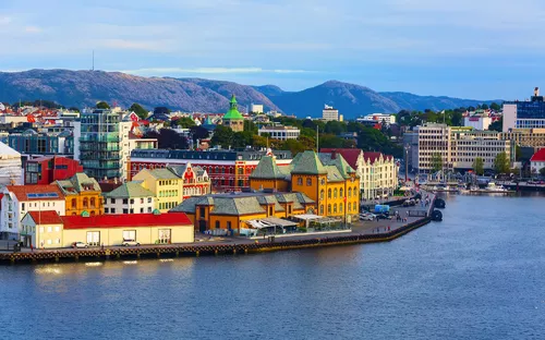 Bunte Gebäude am Wasser mit Bergen im Hintergrund in Bergen, Norwegen.