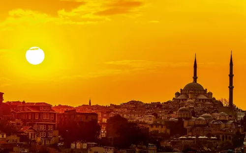 Sonnenuntergang über der Skyline von Istanbul mit einer Moschee und Minaretten im Vordergrund.