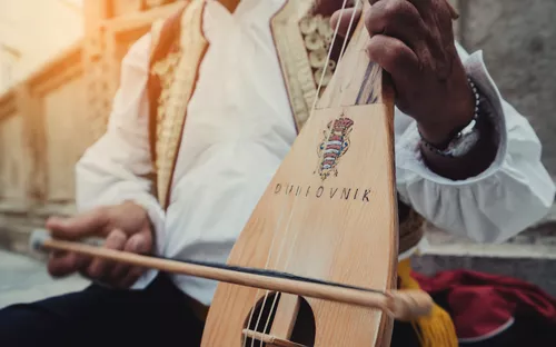 Musiker spielt traditionelle kroatische Lira mit Bogen.