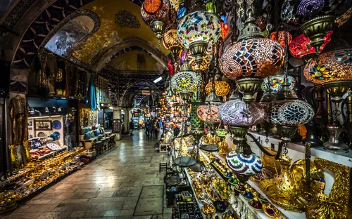 Marktgang mit bunten Mosaiklampen und Waren in einem Basar.