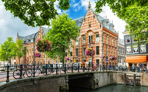 Historische Gebäude und Fahrräder an einem Kanal in Amsterdam.