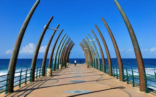 Ansicht einer Pier mit geschwungenen Bögen am Meer unter klarem Himmel