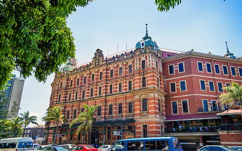 Historisches Gebäude in einer belebten Stadtstraße bei Tag.