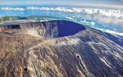 Vulkanlandschaft mit großem Krater und Wolken im Hintergrund