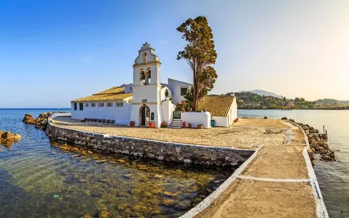 Eine kleine weiße Kirche auf einer Halbinsel im Meer.