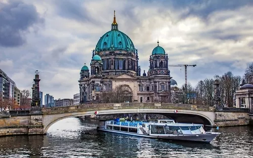 Haus im Barockstil hinter Brücke und Fluss, grauer Himmel