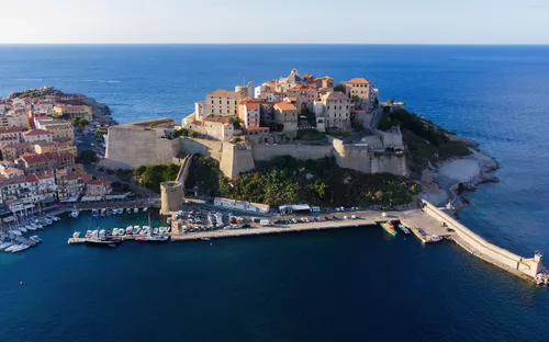 Luftaufnahme einer alten Festung auf einer Insel am Meer, umgeben von blauem Wasser.