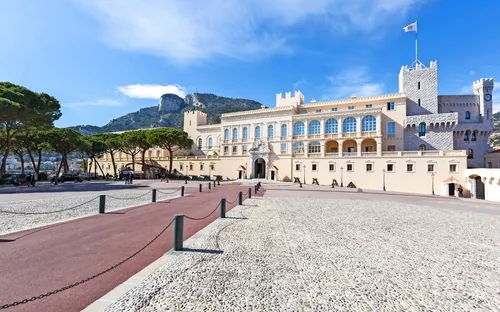 Palast in Monaco mit Bergen und Himmel im Hintergrund.