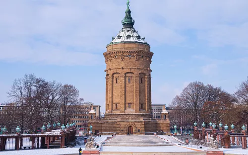 Winterlicher Blick auf den Wasserturm in Mannheim am Friedrichsplatz, umgeben von Schnee.