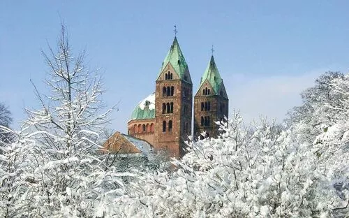 Verschneite Kirche mit zwei Türmen im Winter.