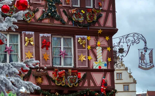 Fachwerkhaus mit festlichen Weihnachtsdekorationen und bunten Geschenken.