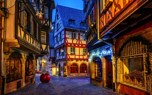 Verschneite Fachwerkhäuser in einer abendlichen Altstadtgasse.