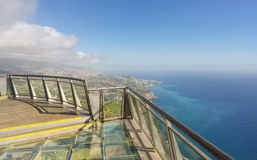 Aussichtsplattform mit Glasboden und Blick auf Küste und Meer.