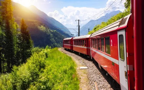 Roter Zug der Rhätischen Bahn auf der Berninabahn in den Schweizer Alpen.