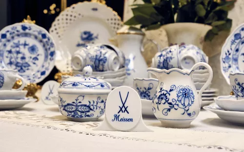 Porzellan mit blauem Blumendekor auf einem Tisch arrangiert.