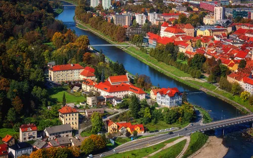 Panoramaansicht von Celje in Slowenien mit Fluss, historischen Gebäuden und grüner Landschaft.