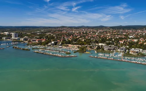 Küste und Hafen von Balatonfüred am Plattensee in Ungarn mit blauem Himmel und Wasser.
