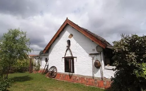Weißes Bauernhaus mit Satteldach und Garten im Vordergrund