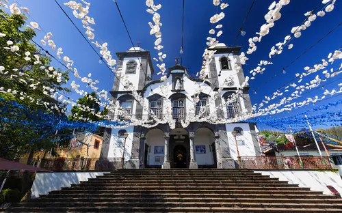 Kirche mit dekorierten Girlanden und blauen Himmel im Hintergrund.