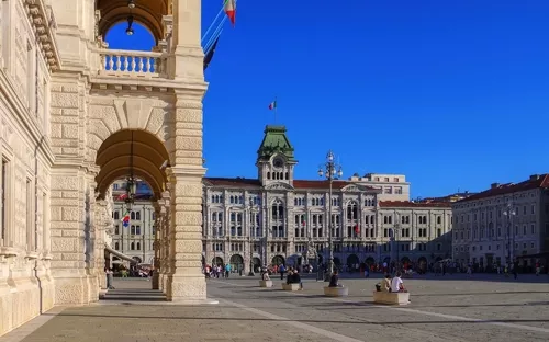 Platz mit historischer Architektur und Menschen an einem sonnigen Tag.